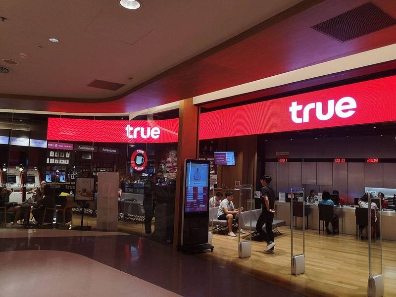 The red True shop at the Central Silom Complex in Bangkok, with a service counter and waiting seats